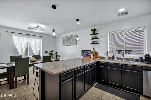 a kitchen with a sink a counter space appliances and cabinets