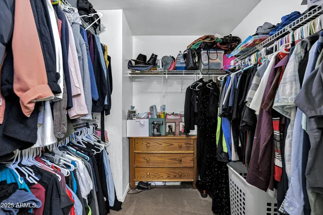 a view of walk in closet with clothes and shoes