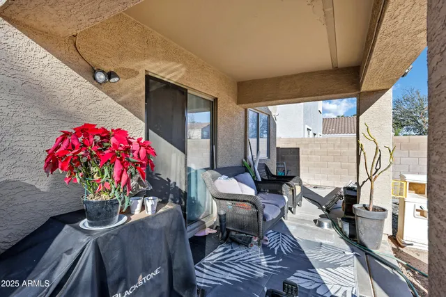a dining room with furniture a potted plant and a large window