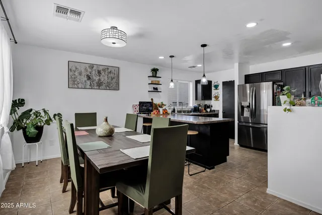 a kitchen with a refrigerator a stove a dining table and chairs