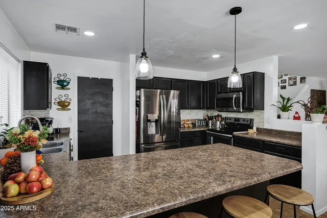 a kitchen with stainless steel appliances granite countertop a sink refrigerator and microwave