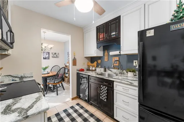 a kitchen with stainless steel appliances granite countertop a stove top oven a sink dishwasher and a refrigerator