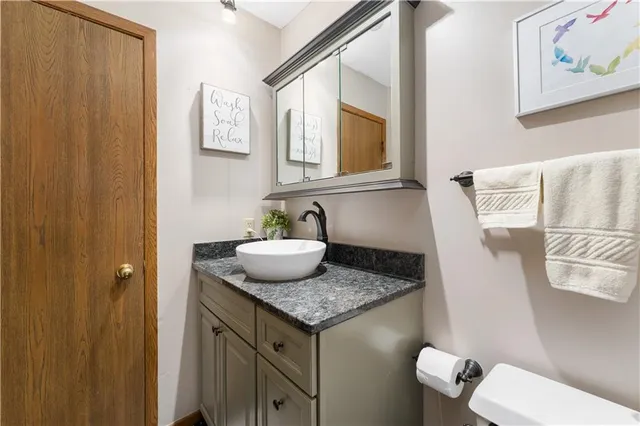 a bathroom with a granite countertop sink and a mirror