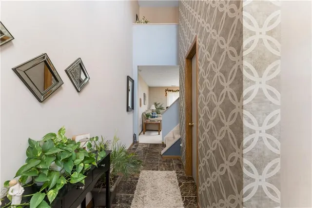 a hallway with painting and a potted plant