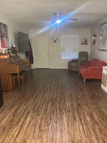 a living room with furniture and a wooden floor