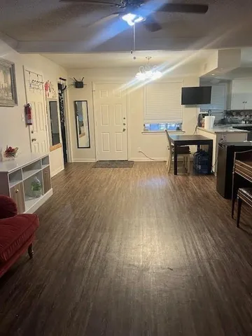 a living room with stainless steel appliances kitchen island hardwood floor and a view of kitchen