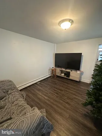 a view of room with wooden floor and flat screen tv