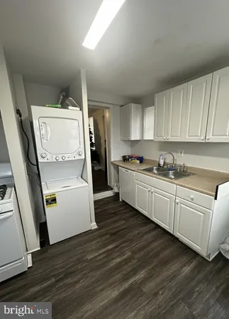 a kitchen with a refrigerator and white cabinets