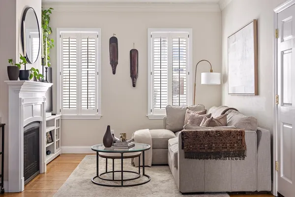a living room with furniture a fireplace and a large window