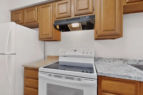a kitchen with granite countertop white cabinets and white appliances