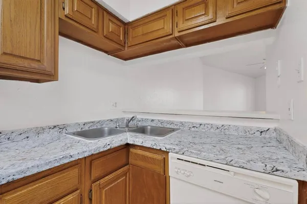 a kitchen with granite countertop cabinets sink and stove