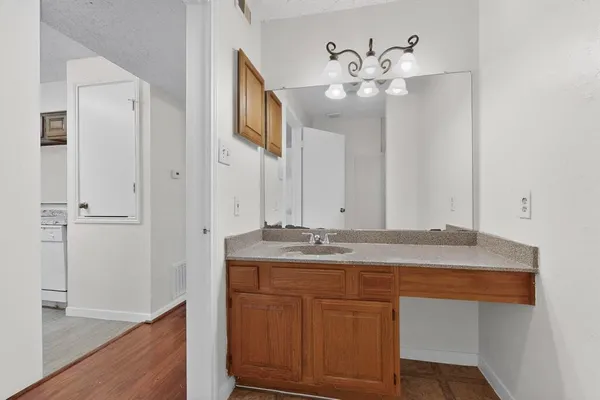 a bathroom with a granite countertop sink a mirror and a vanity