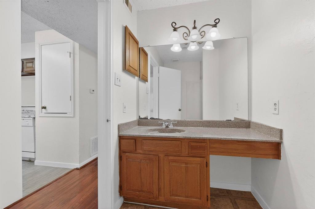 8545 Midpark Road, Unit 16 Dallas, TX 75240 - Photo 18 of 29 a bathroom with a granite countertop sink a mirror and a vanity