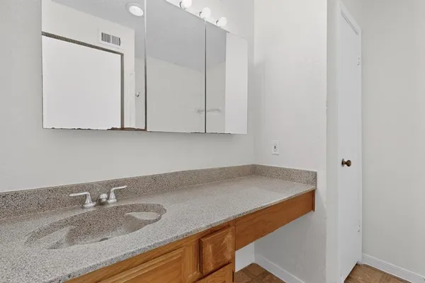 a room with granite countertop white cabinets and a sink