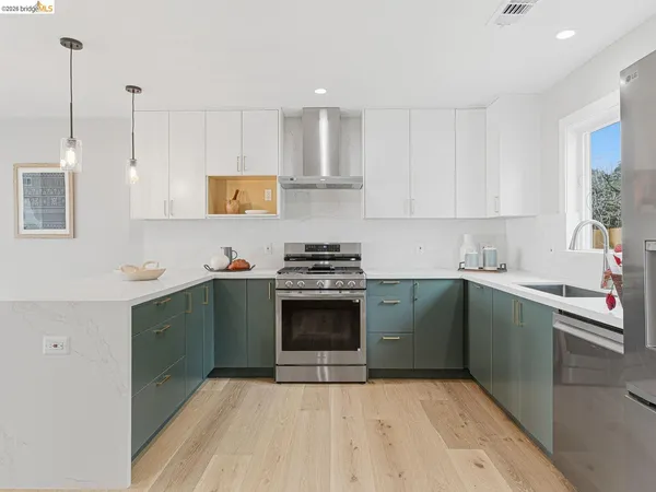 a kitchen with kitchen island white cabinets and stainless steel appliances