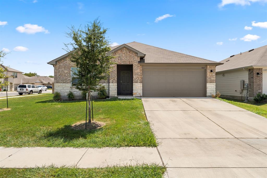 15217 Upland Willow Road Austin, TX 78724 - Photo 1 of 25 Lovely home with brick siding, a garage, stone siding, and driveway