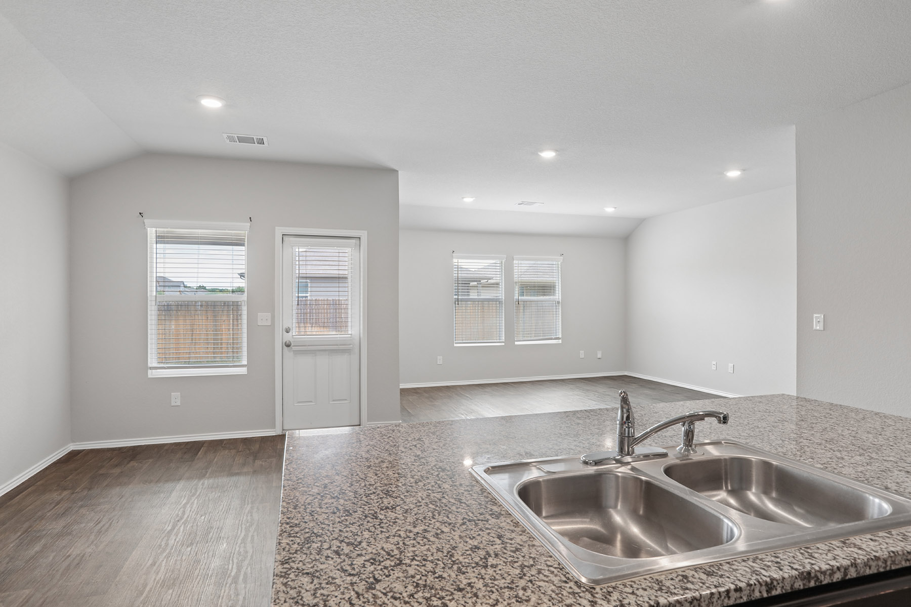 15217 Upland Willow Road Austin, TX 78724 - Photo 25 of 25 Kitchen with wood finished floors, open floor plan, vaulted ceiling, and recessed lighting
