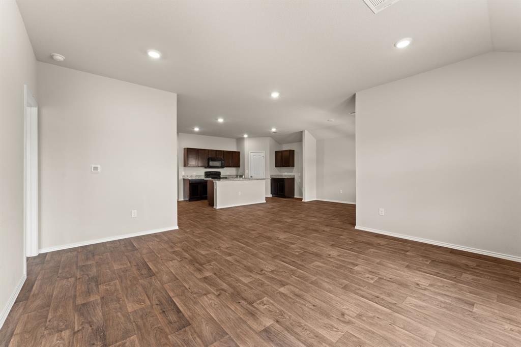 15217 Upland Willow Road Austin, TX 78724 - Photo 15 of 25 Unfurnished living room with dark wood finished floors and recessed lighting