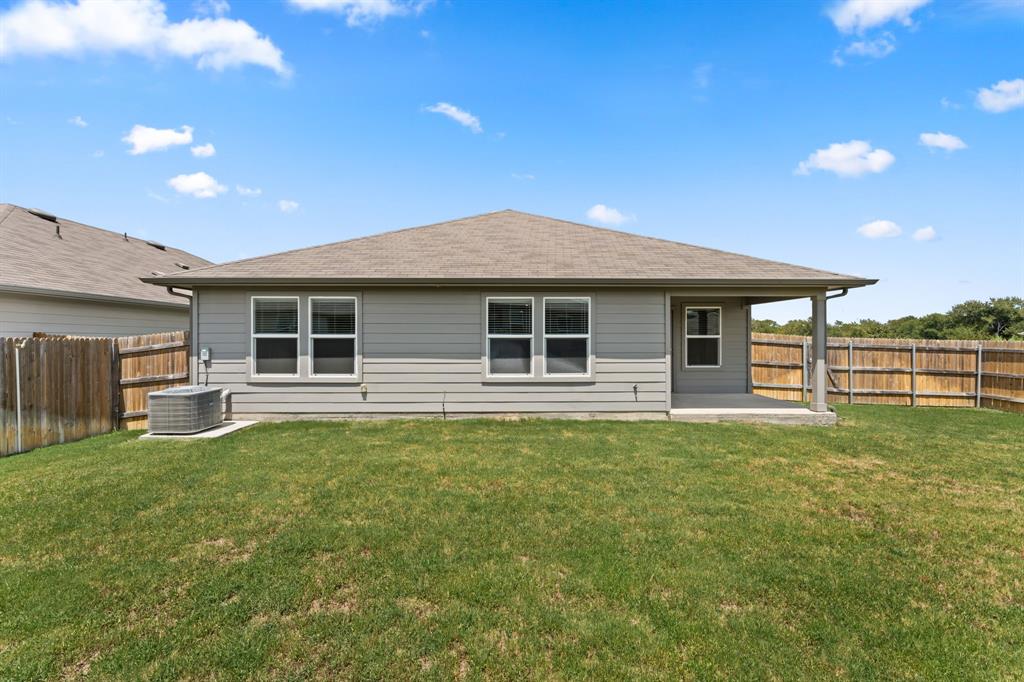 15217 Upland Willow Road Austin, TX 78724 - Photo 24 of 25 Back of property featuring a patio and a fenced backyard