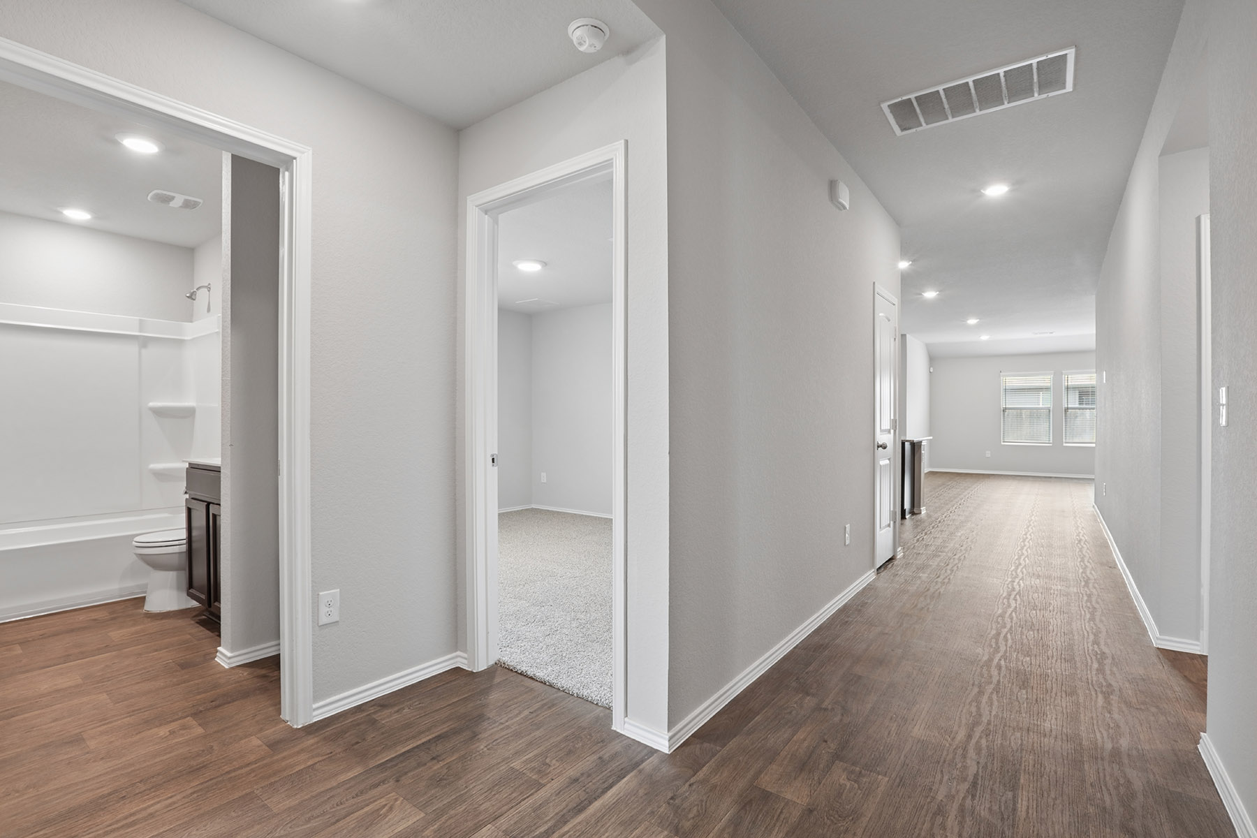 15217 Upland Willow Road Austin, TX 78724 - Photo 6 of 25 Hallway featuring dark wood-style flooring and recessed lighting