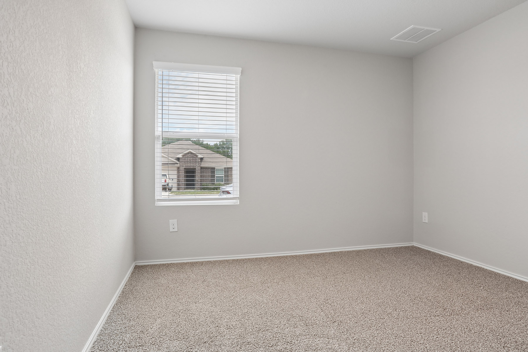 15217 Upland Willow Road Austin, TX 78724 - Photo 9 of 25 Unfurnished room with light carpet and a textured wall