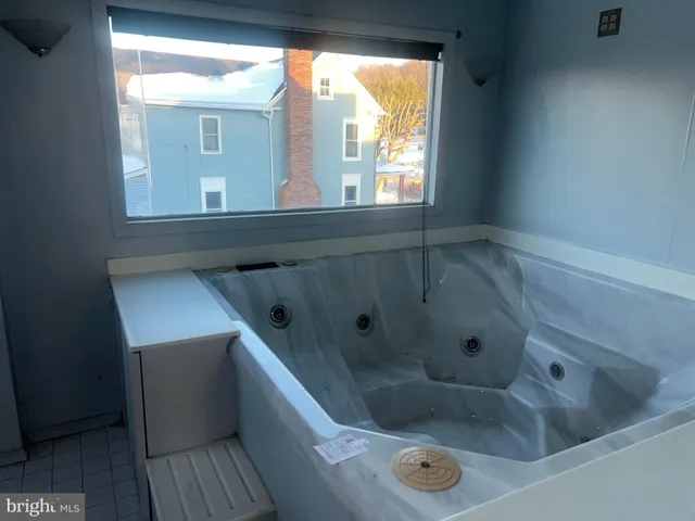 a bathroom with a tub a sink and a window