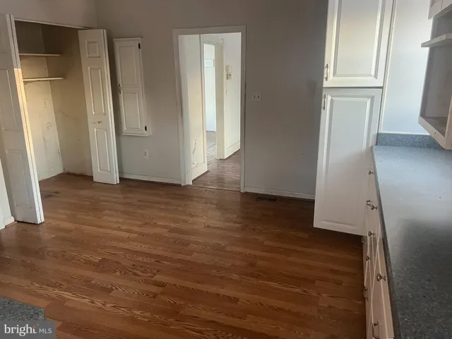 an empty room with wooden floor and a window