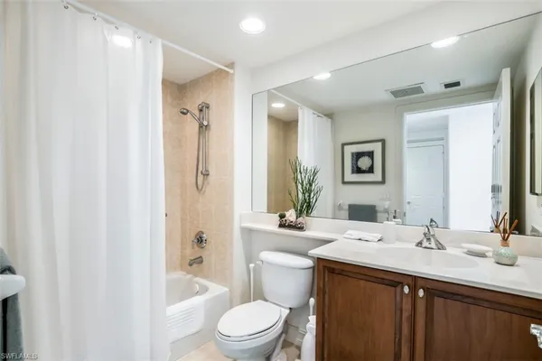 a bathroom with a sink a toilet a large mirror and shower