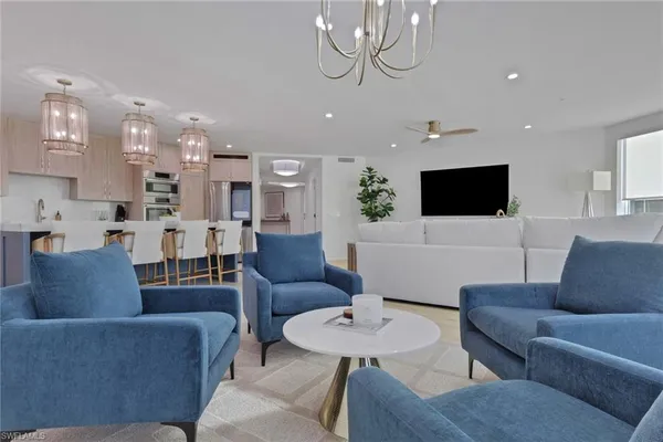 a living room with furniture kitchen and a flat screen tv