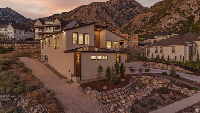 1445 Jacob Road Sandy, UT 84092 - Photo 57 of 65 Contemporary architectural design with a sloped roofline, multiple windows, and exterior wall sconces