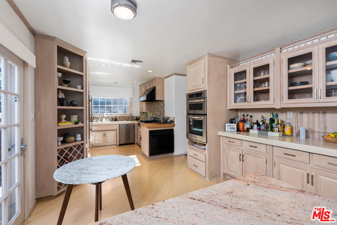 4247 Sespe Avenue Sherman Oaks, CA 91403 - Photo 11 of 31 a kitchen with a refrigerator a stove cabinets and a dining table