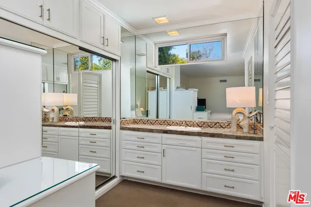 a bathroom with a granite countertop sink mirror and window