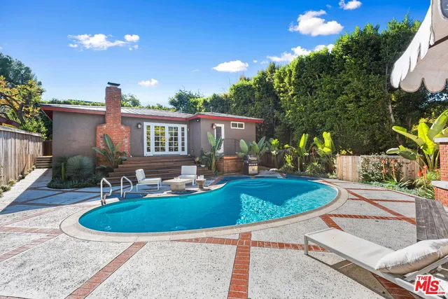 a view of a house with backyard and sitting area
