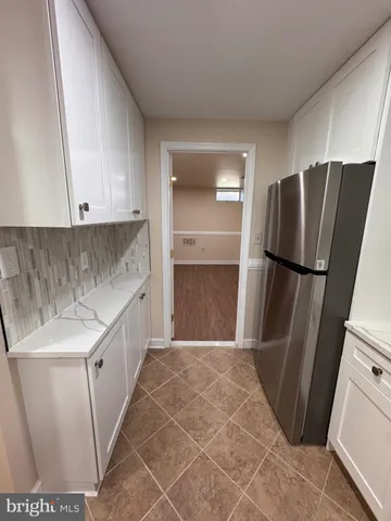 a kitchen with granite countertop a refrigerator and a sink