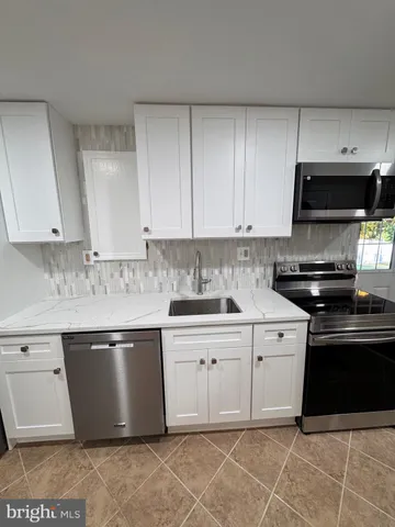 a kitchen with stainless steel appliances granite countertop a sink and a stove