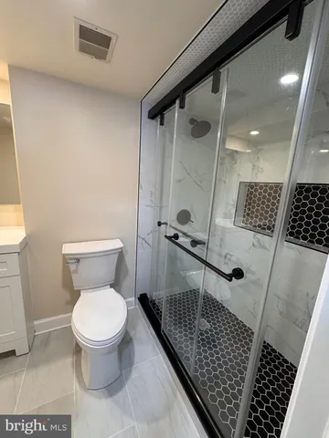 a bathroom with a toilet and a shower
