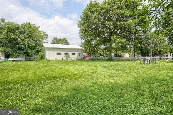 a view of a house with a big yard and large trees