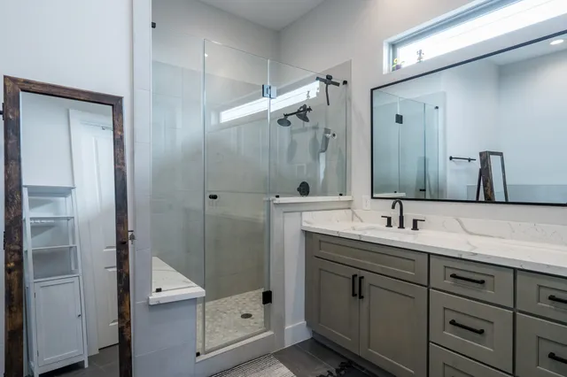 a bathroom with a white tub shower and sink