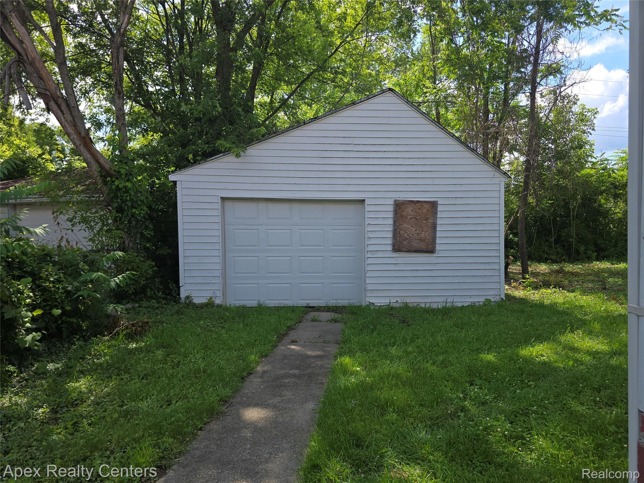 7671-7675 Evergreen Road Detroit, MI 48228 - Photo 16 of 84 Detached garage with horizontal siding and a paneled garage door