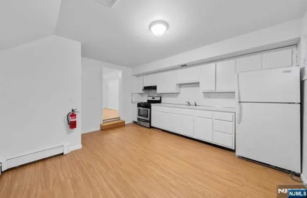 a view of a kitchen with wooden floor and electronic appliances