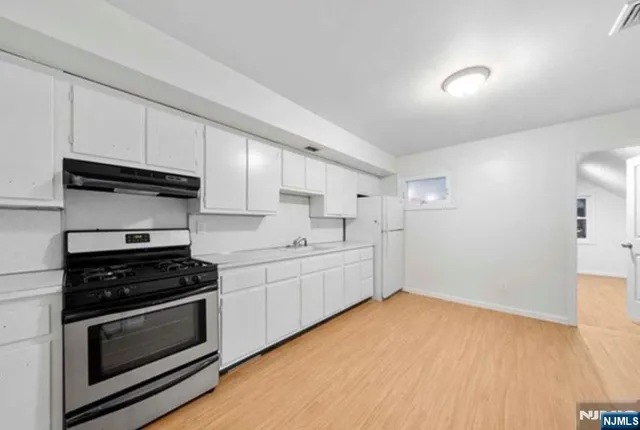 a kitchen with granite countertop a stove and a sink