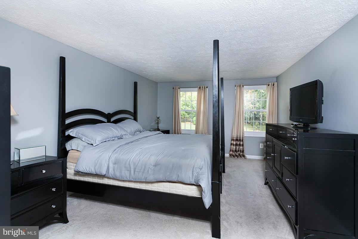 5750 Heming Avenue Springfield, VA 22151 - Photo 21 of 30 a bedroom with a bed and a flat tv screen on wall