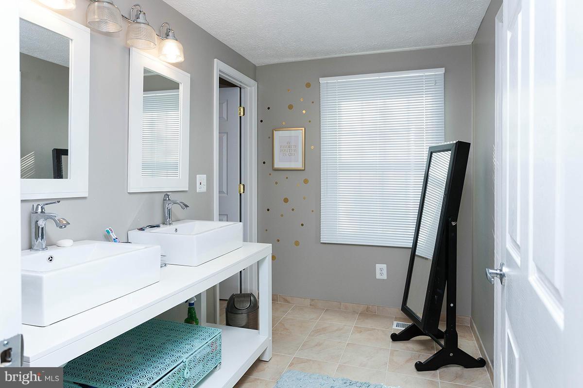 5750 Heming Avenue Springfield, VA 22151 - Photo 23 of 30 a bathroom with a sink a double vanity and a mirror