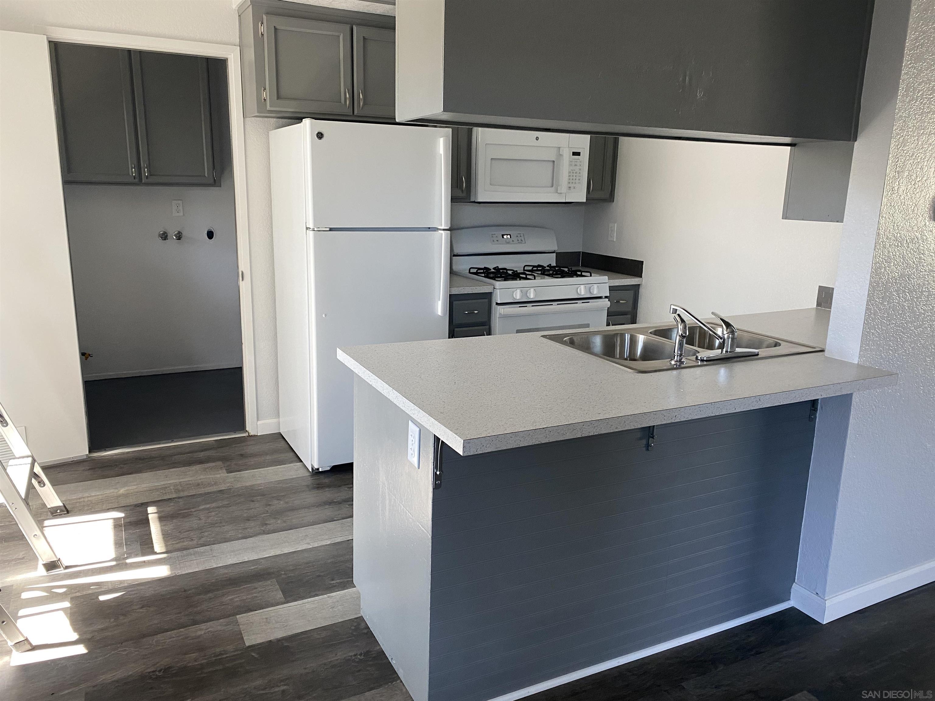 1122 Oro Street El Cajon, CA 92021 - Photo 4 of 8 a kitchen with a refrigerator and a sink