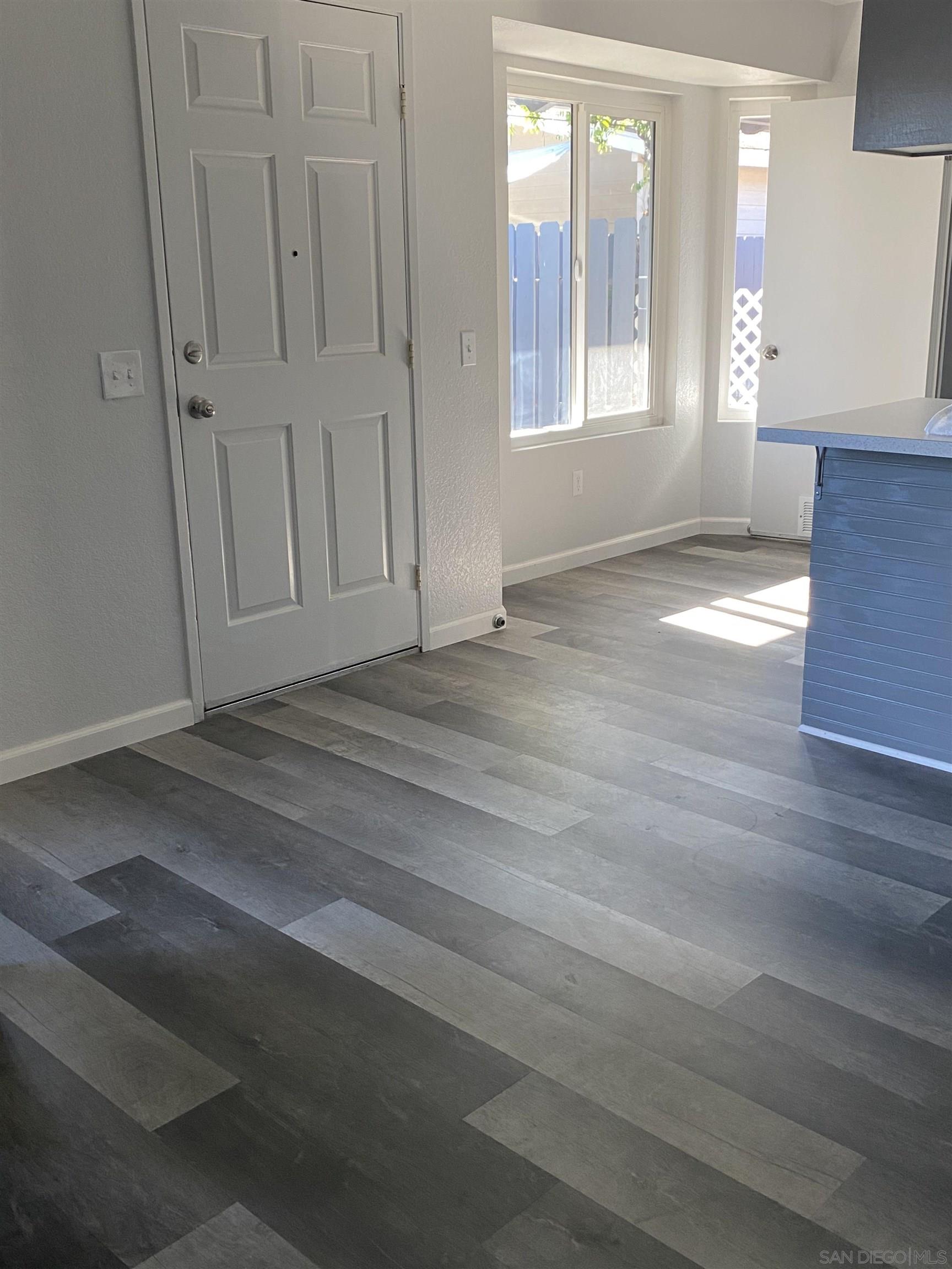 1122 Oro Street El Cajon, CA 92021 - Photo 5 of 8 an empty room with wooden floor and windows