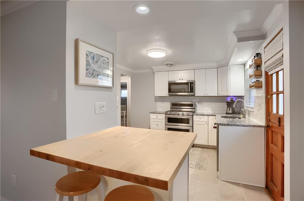 445 Rockhill Road Pittsburgh, PA 15243 - Photo 10 of 31 a kitchen with stainless steel appliances granite countertop a refrigerator a stove top oven a sink dishwasher and white cabinets with wooden floor