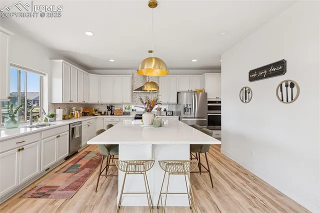 a large kitchen with a table chairs and a refrigerator