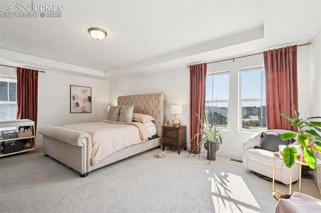 a spacious bedroom with a bed couch and a large window