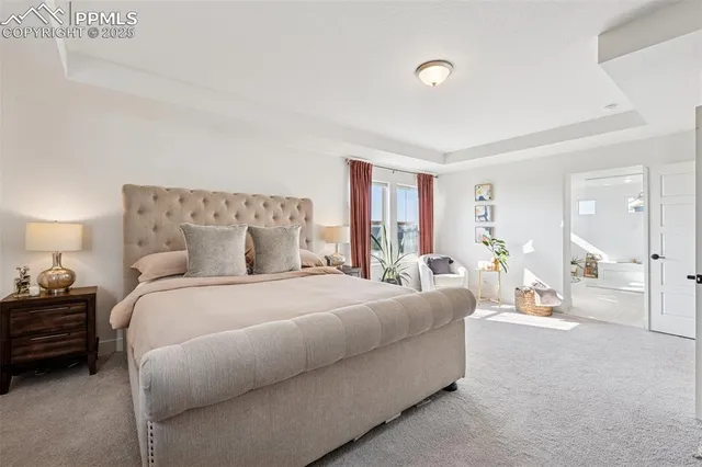 a bedroom with a bed a couch and large window