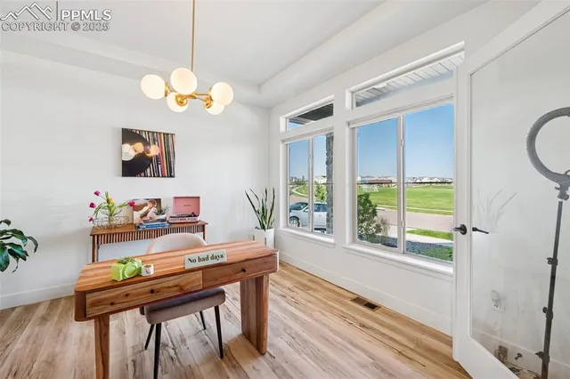 a view of a dining room with furniture a chandelier and wooden floor